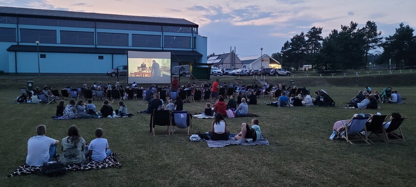 Ludzie oglądający film w plenerze