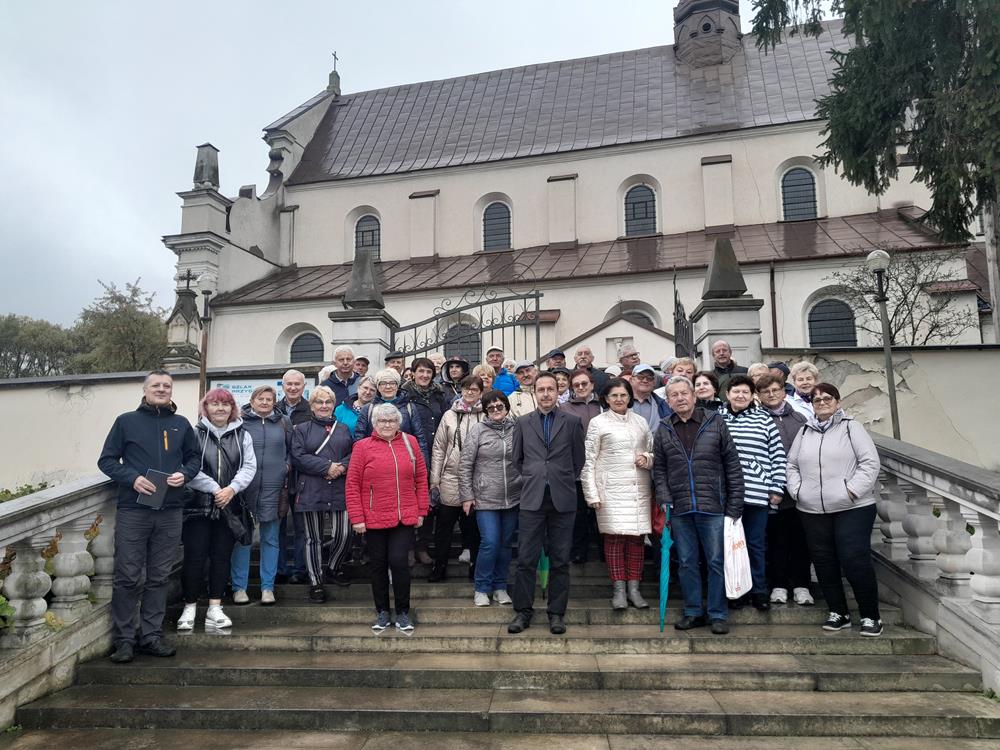 Zdjęcie grupowe osób na schodach, w tle kościół