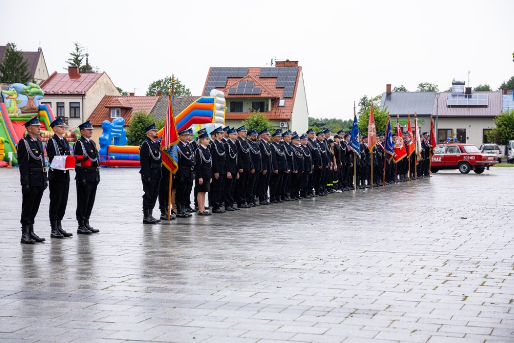 Strażacy w umundurowaniu stojący w szeregu