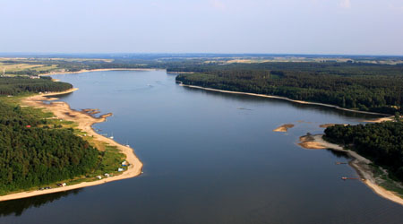 Jezioro Chańcza, na zdjęciu pośrodku zbiornik wodny, po bokach plaże i lasy